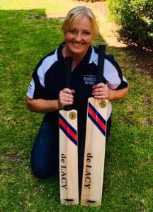 Clare Johnston at her workshop in South Gippsland proudly holding two of her handmade cricket bats